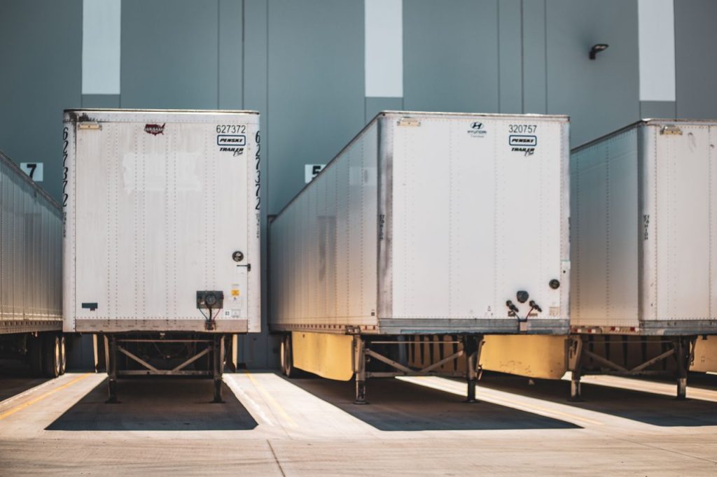 Mastering the First Impression: Your intriguing post title goes here A row of freight trailers parked at a commercial loading dock, emphasizing transportation and logistics.