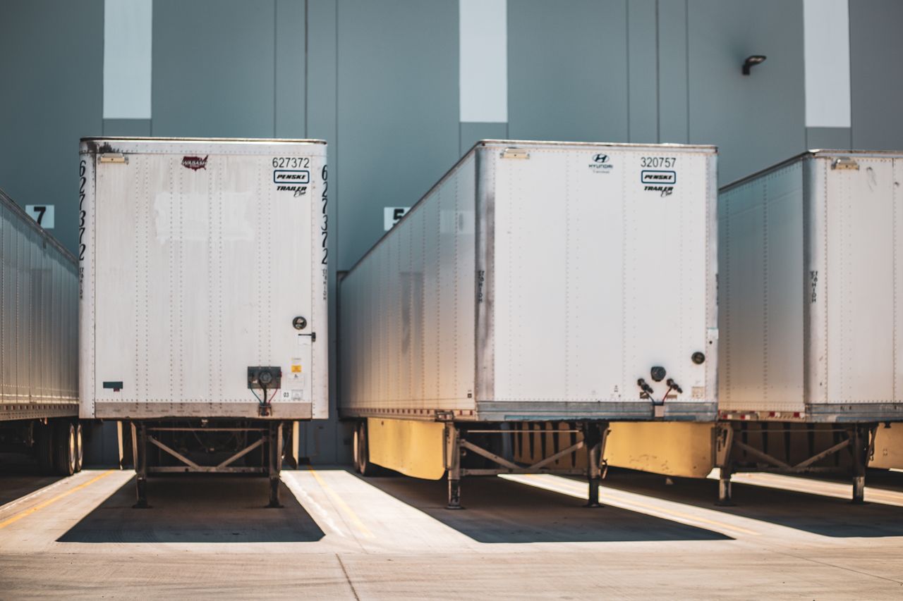 A row of freight trailers parked at a commercial loading dock, emphasizing transportation and logistics.
